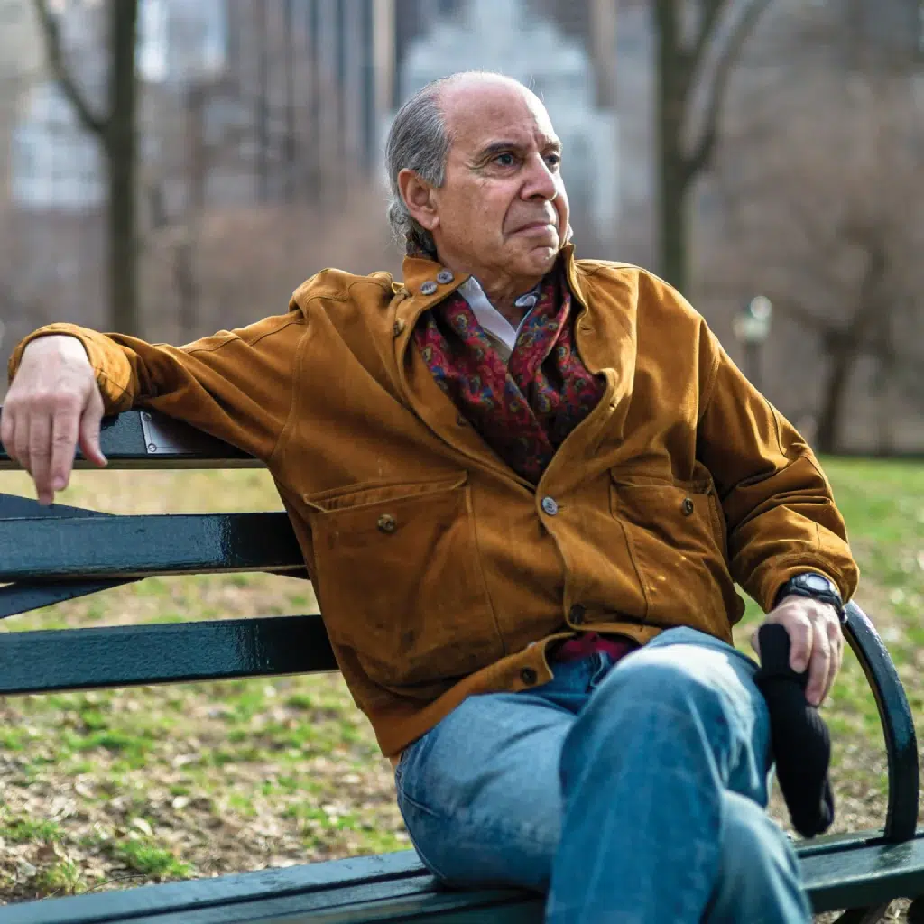 Iranian-American author, Hassan Nemazee, poses on bench in central park, NYC.